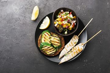 Toast with zucchini grill and salad of olives, cucumbers, tomato, sweet red onion, yellow chili pepper with grilled chicken breast. Top View.