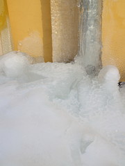 Gutter in the ice against a yellow wall