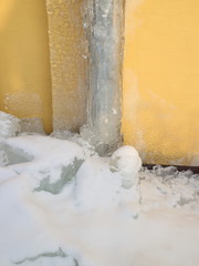 Gutter in the ice against a yellow wall