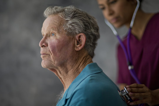 Doctor listening to a senior patient's heartbeat with a stethoscope.