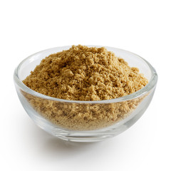 Finely ground ginger in glass bowl isolated on white.