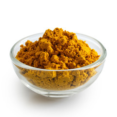 Curry powder in glass bowl isolated on white.