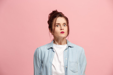 Portrait of an angry woman looking at camera isolated on a pink background