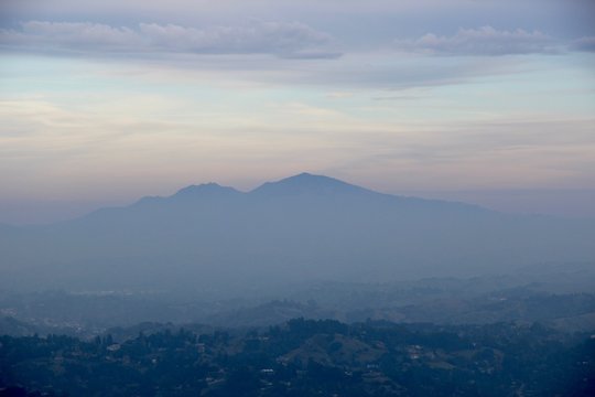 Soft light surrounds the mountain peak and mist fills the air