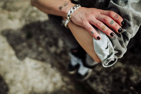 Crop tattooed person with rolled sleeves