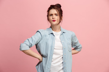 Portrait of an angry woman looking at camera isolated on a pink background