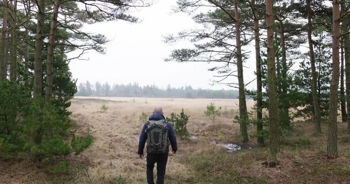 man traveling and hiking in nordic nature by lakes and in forest