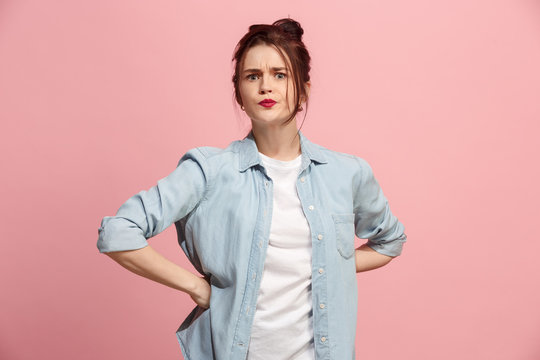 Portrait of an angry woman looking at camera isolated on a pink background