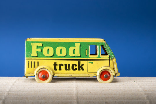 Food Truck, Vintage Tin Toy Van On Blue Background.