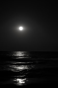 Fototapeta moon at night, moonlight on the waves of the sea. Horizon. Long exposure. Black and white photo.