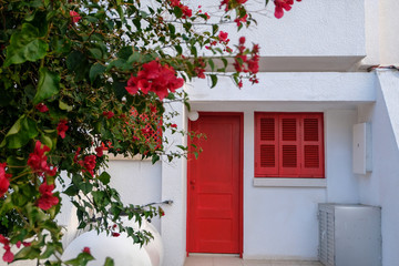 White house with red door, window and flowers