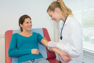 doctor doing a blood test on female patient