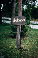 Wooden plaque with inscription photozone on the pine