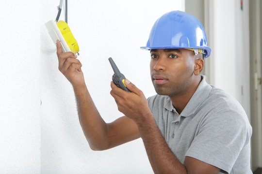 electrician installs paired socket on the wall