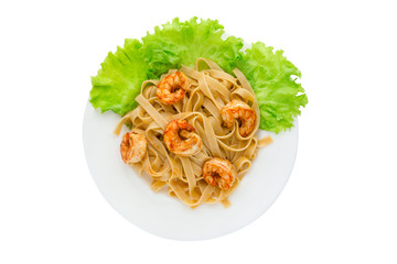Boiled pasta with fried shrimp. Tagliatelle macaroni are observed with fried langoustines and lettuce leaves.
