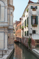 Fototapeta na wymiar View of one of the many canals of Venice, Italy. Venice is a popular tourist destination of Europe.