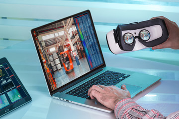 Man with vr virtual reality device for virtual warehouse control /Operator with computer of augmented reality is ready to make a virtual visit to the factory