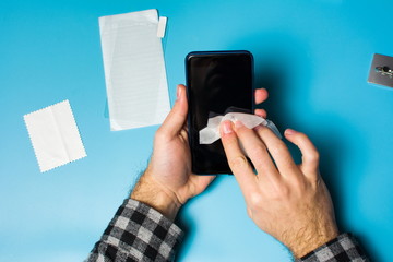 Man cleaning phone screen to apply protective glass