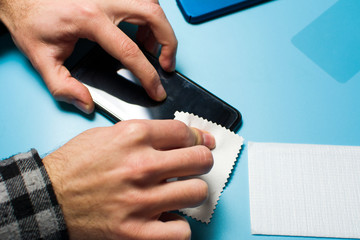 Man applying protective tempered glass to phone screen