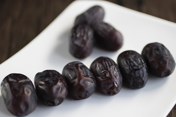 Dried dates on white plate.
