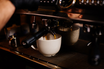 Fototapeta na wymiar Barista poring / making coffee latte at coffee machine. Close-up barista preparing cappuccino.