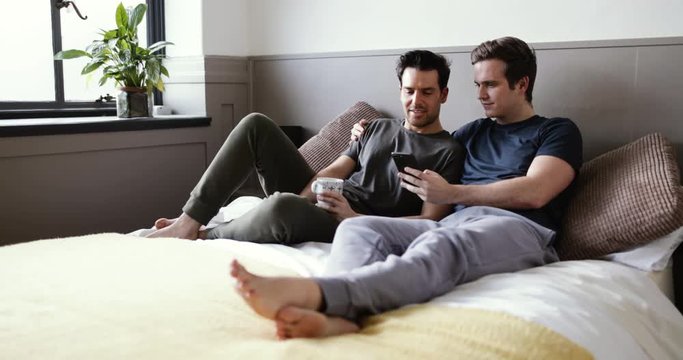 Young male couple looking at smarphone together