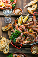 Delicous fried scampi shrimps with wine and bread top view, beckground