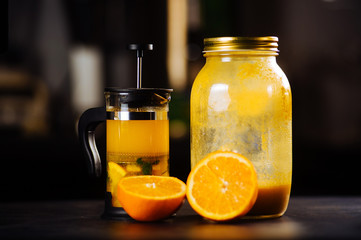 Tea set of tea pot and cup with orange and sea buckthorn on table in restaurant.