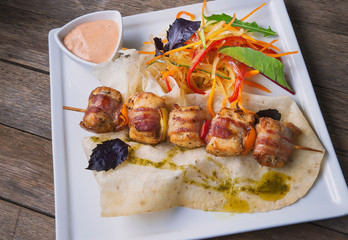 Baked fat on the skewer with salad