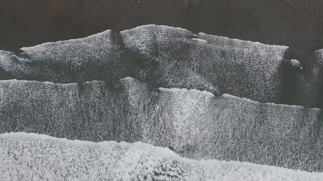 Top aerial view frop drone of Tropical exotic beach with volcanic sand in Bali, Indonesia