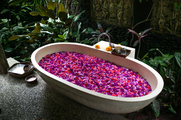 Outdoor bath with tropical pink flowers for relax.Spa,organic and skin care concept. © tatyanasuyarova
