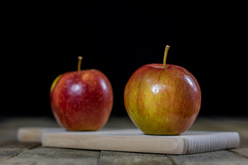 Big red apples in a dark wooden box. Wooden crate and apples on a wooden table in the kitchen.