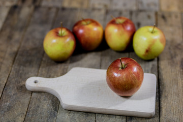Big red apples in a dark wooden box. Wooden crate and apples on a wooden table in the kitchen.