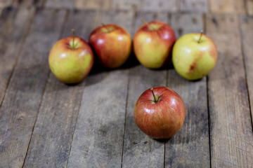Big red apples in a dark wooden box. Wooden crate and apples on a wooden table in the kitchen.