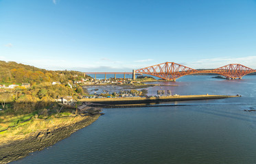 Fototapeta na wymiar A view from the east footpath of the Forth Road Bridge, looking over North Queensferry towords the old and famous Rail Bridge.