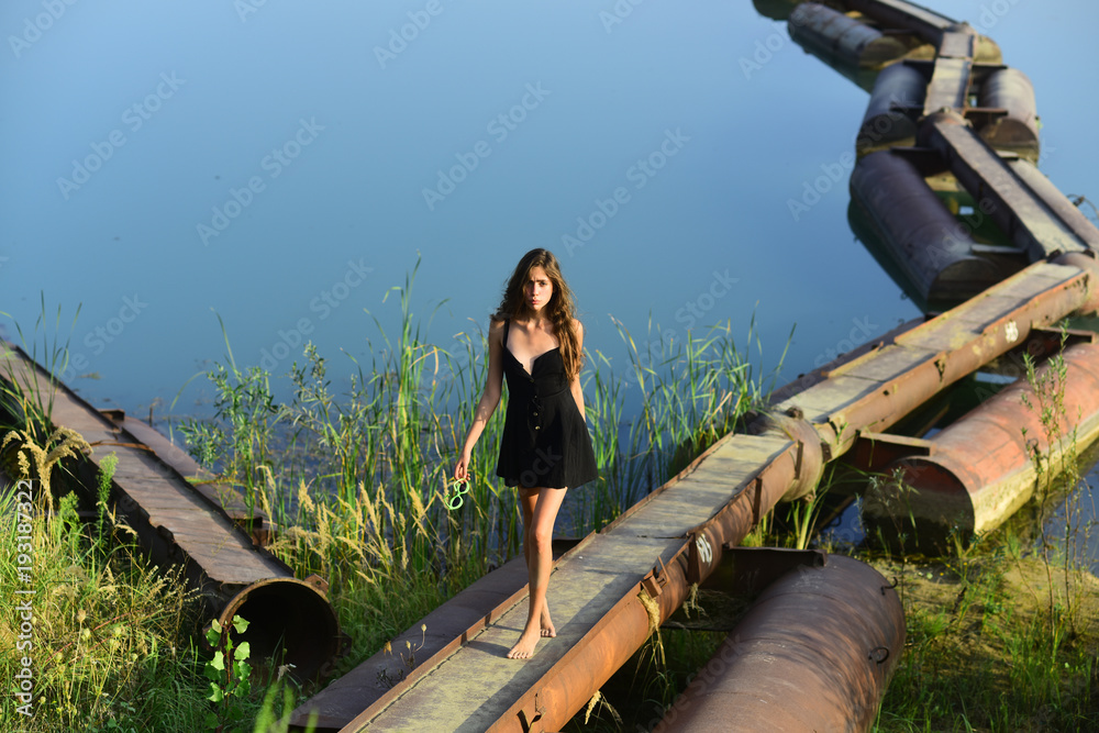 Wall mural woman walk on metal pontoon bridge over river