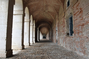 Fototapeta na wymiar Old archway, destroyed brick wall and stone colonnade in Aranjuez, Spain
