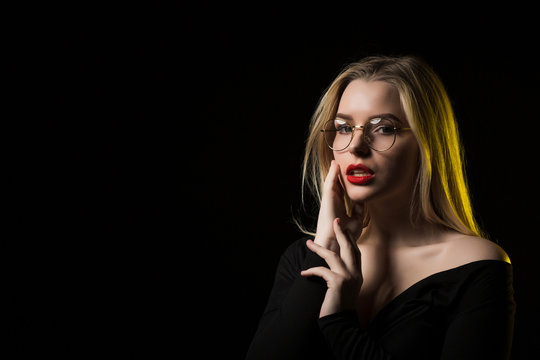Stylish young model wearing glasses, posing in the shadow