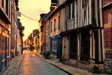 Old street in the Normandy town of Honfleur, France with light of the rising sun © Jenifoto
