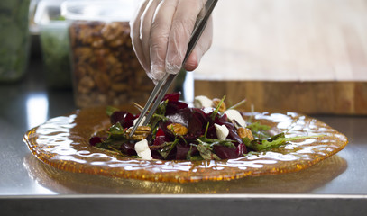 Chef preparing and serving a salad in the kitchen of the restaurant