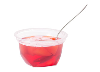 Cup of jelly with fruit red peach with spoon isolation