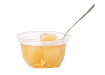 Cup of jelly with fruit yellow pineapple with spoon isolation