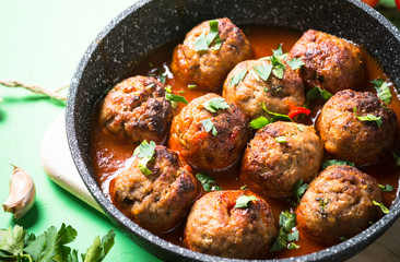 Meat balls in tomato sauce in a frying pan. 