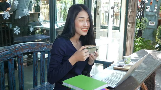 4k of young woman using laptop at cafe while drinking coffee