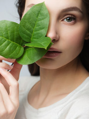 Portrait beautiful woman face portrait with green leaf , concept for skin care or organic cosmetics