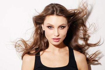 Portrait beautiful young woman with long brown hair. Pretty model poses at studio.