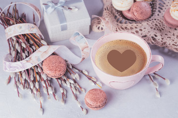 Pink coffee mug with sweet pastel french macaroons, gift box and pussy willow