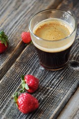 Fresh Americano coffee and strawberries on the table 