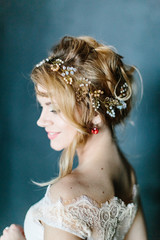 Young beautiful bride with a beautiful diadem in the hair poses standing on dark background.