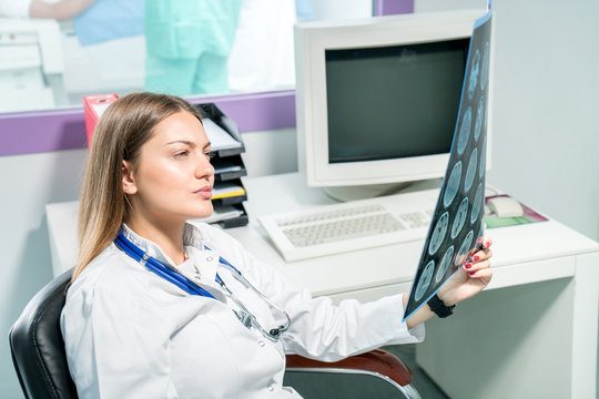 Female doctor looking at an x-ray in her office